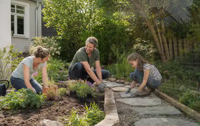 Familie geht auf einem Weg durch einen abwechslungsreich gestalteten Garten; Thema Japanischer Garten, Schwerpunkt Anleitung; Umsetzung.