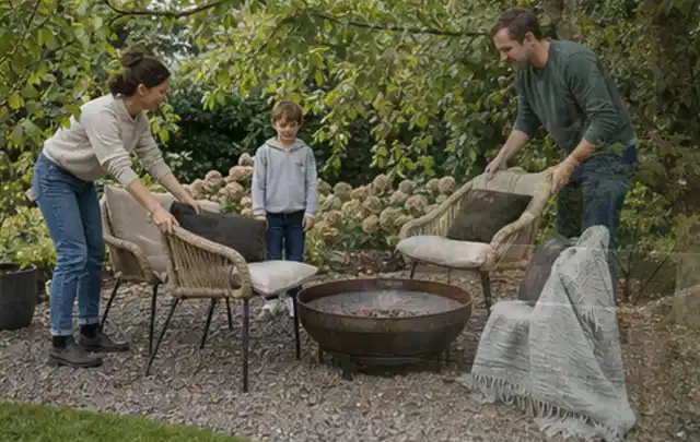 Familie stellt wetterfeste Sessel an einem geschützten Sitzplatz im Garten auf; Thema Japanischer Garten, Schwerpunkt Anleitung; Praxisalltag.