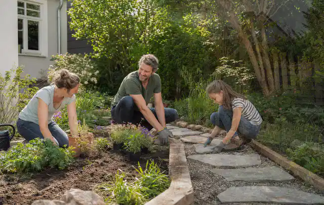 Familie geht auf einem Weg durch einen abwechslungsreich gestalteten Garten; Thema Japanischer Garten, Schwerpunkt Beleuchtung; Kontrolle.