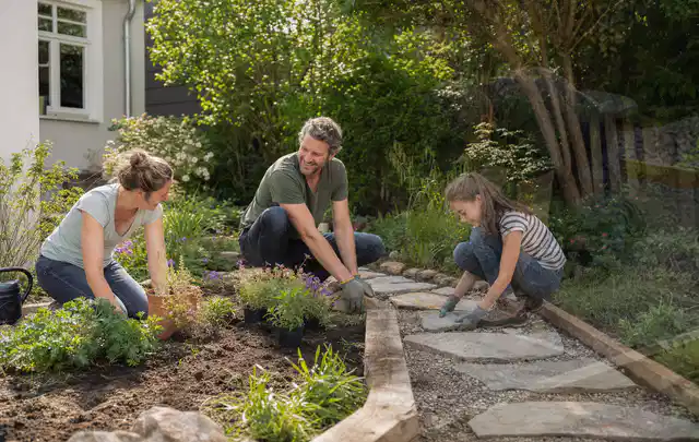 Familie geht auf einem Weg durch einen abwechslungsreich gestalteten Garten; Thema Japanischer Garten, Schwerpunkt Wegeführung; Praxisalltag.