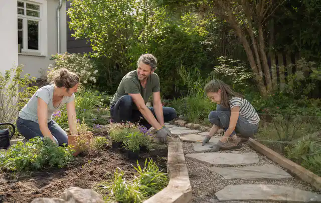 Familie geht auf einem Weg durch einen abwechslungsreich gestalteten Garten; Thema Kleingarten, Schwerpunkt Anleitung; Kontrolle.