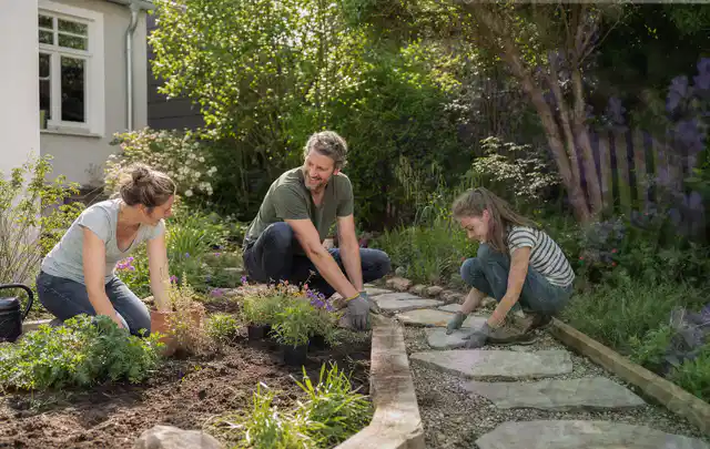 Familie geht auf einem Weg durch einen abwechslungsreich gestalteten Garten; Thema Kleingarten, Schwerpunkt Garten gestalten; Ausgangslage.