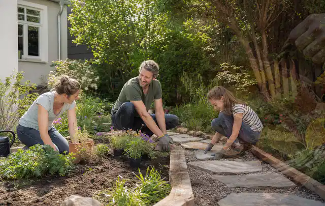 Familie geht auf einem Weg durch einen abwechslungsreich gestalteten Garten; Thema Kleingarten, Schwerpunkt Naturgarten; Ausgangslage.