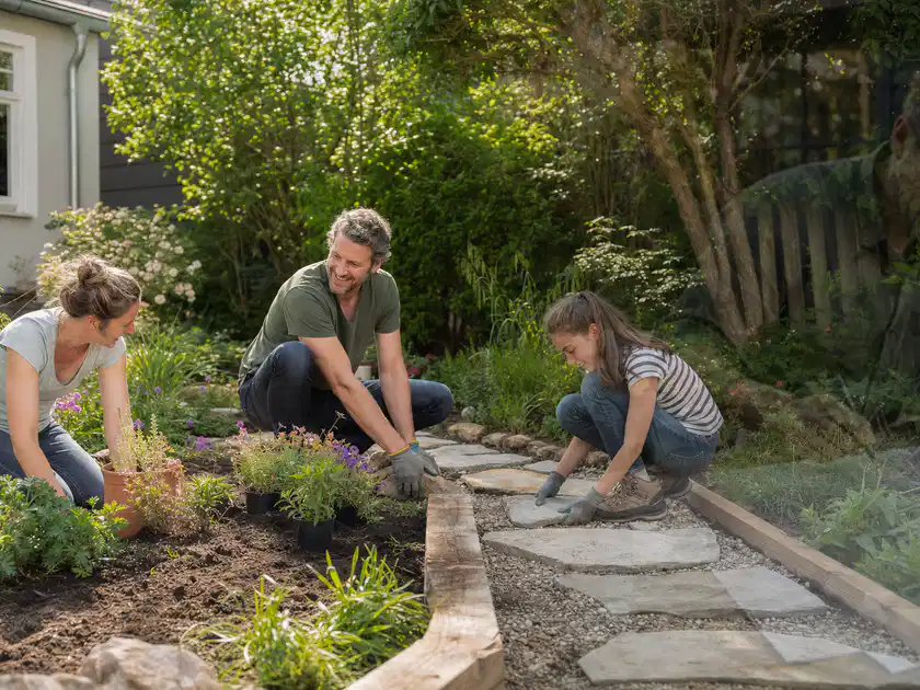 Familie geht auf einem Weg durch einen abwechslungsreich gestalteten Garten; Thema Kleingarten, Schwerpunkt Pflegeleichtigkeit; Titelbild.