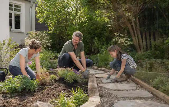 Familie geht auf einem Weg durch einen abwechslungsreich gestalteten Garten; Thema Kleingarten, Schwerpunkt Planung; Kontrolle.