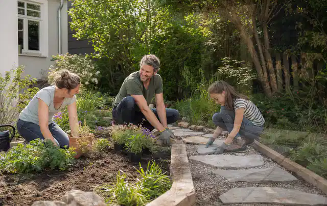 Familie geht auf einem Weg durch einen abwechslungsreich gestalteten Garten; Thema Kleingarten, Schwerpunkt Privatsphäre; Umsetzung.