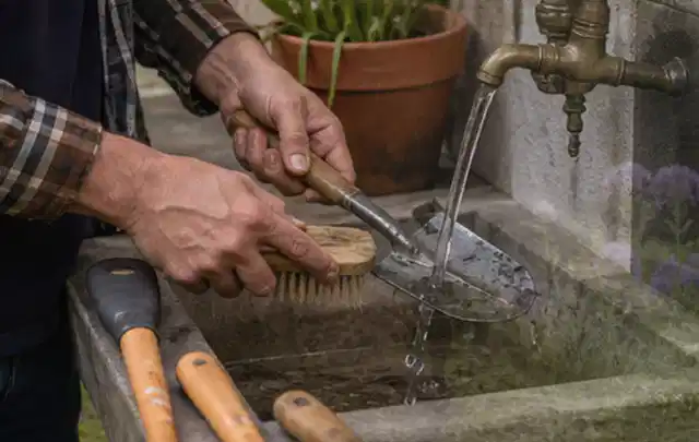 Hände reinigen gebrauchte Gartengeräte mit Bürste und Wasser am Außenbecken; Thema Komposter, Schwerpunkt Checkliste; Ausgangslage.