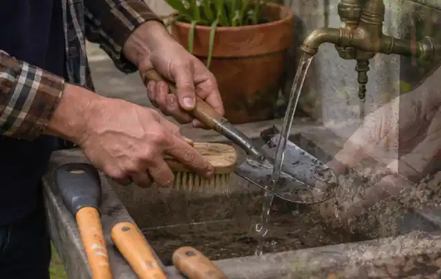 Hände reinigen gebrauchte Gartengeräte mit Bürste und Wasser am Außenbecken; Thema Komposter, Schwerpunkt Testkriterien; Praxisalltag.