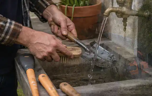 Hände reinigen gebrauchte Gartengeräte mit Bürste und Wasser am Außenbecken; Thema Kress Mission, Schwerpunkt Kaufberatung; Kontrolle.