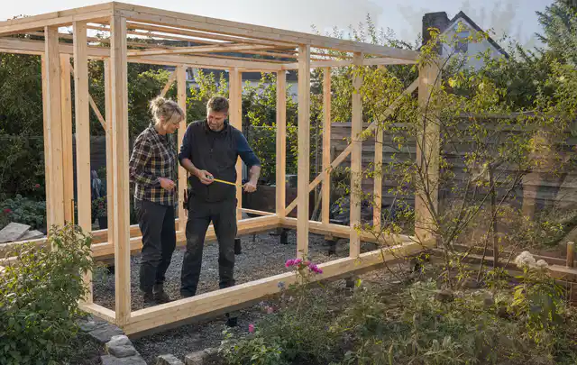 Person plant den Bau eines Gartenhauses auf einer vorbereiteten Fläche; Thema Lagerhaus im Garten, Schwerpunkt Baurecht; Ergebnis.