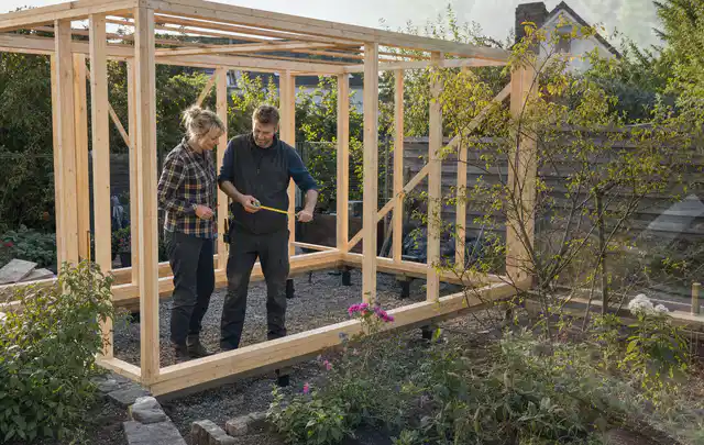 Person plant den Bau eines Gartenhauses auf einer vorbereiteten Fläche; Thema Lagerhaus im Garten, Schwerpunkt Pflege; Umsetzung.