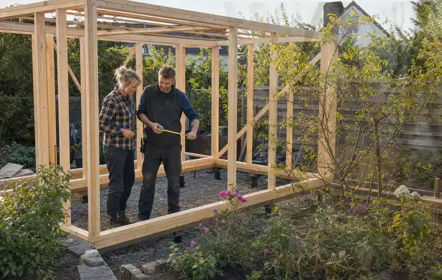 Person plant den Bau eines Gartenhauses auf einer vorbereiteten Fläche; Thema Lagerhaus im Garten, Schwerpunkt Winterschutz; Umsetzung.