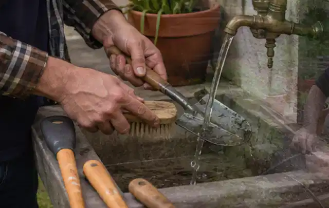 Hände reinigen gebrauchte Gartengeräte mit Bürste und Wasser am Außenbecken; Thema Mähroboter für große Gärten, Schwerpunkt Kaufberatung; Ergebnis.
