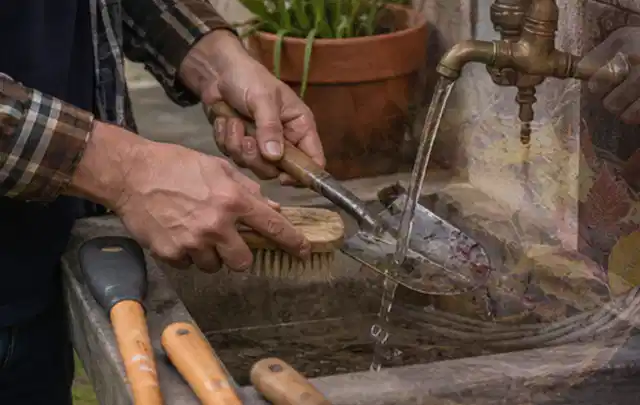 Hände reinigen gebrauchte Gartengeräte mit Bürste und Wasser am Außenbecken; Thema Mähroboter für kleine Gärten, Schwerpunkt Nachhaltigkeit; Ausgangslage.