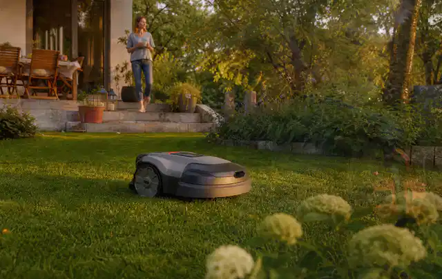 Mähroboter fährt am Abend über einen Rasen im Familiengarten; Thema Mähroboter Messer, Schwerpunkt Systemvergleich; Ergebnis.