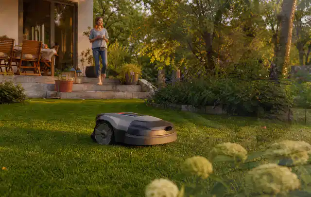 Mähroboter fährt am Abend über einen Rasen im Familiengarten; Thema Mähroboter mit GPS, Schwerpunkt Dimensionierung; Ergebnis.