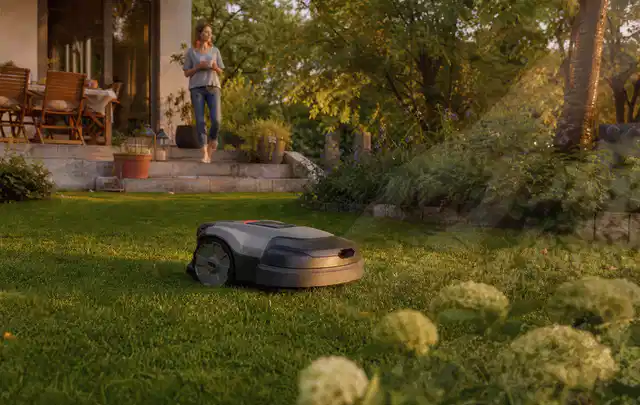 Mähroboter fährt am Abend über einen Rasen im Familiengarten; Thema Mammotion Luba, Schwerpunkt Fehlerhilfe; Ergebnis.