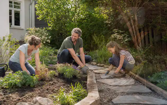 Familie geht auf einem Weg durch einen abwechslungsreich gestalteten Garten; Thema Mediterraner Garten, Schwerpunkt Kosten; Ausgangslage.