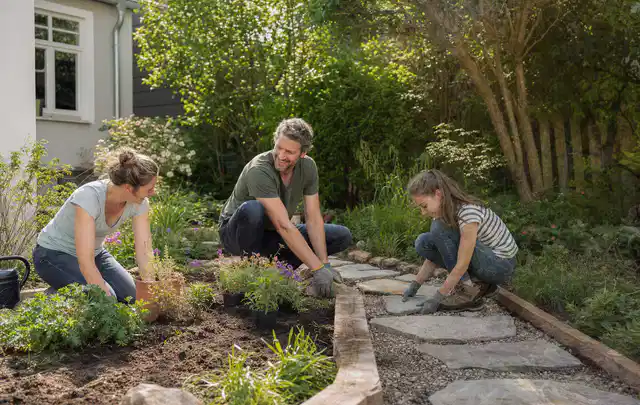 Familie geht auf einem Weg durch einen abwechslungsreich gestalteten Garten; Thema Mediterraner Garten, Schwerpunkt Naturgarten; Umsetzung.