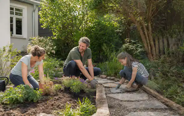 Familie geht auf einem Weg durch einen abwechslungsreich gestalteten Garten; Thema Metallzäune, Schwerpunkt Gärten mit kleiner Fläche; Ausgangslage.