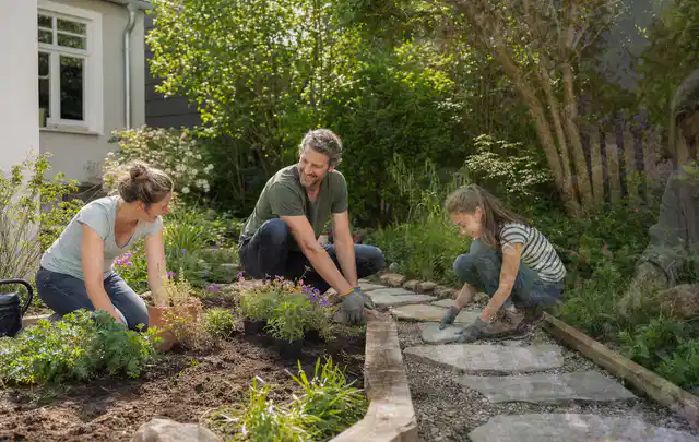 Familie geht auf einem Weg durch einen abwechslungsreich gestalteten Garten; Thema Metallzäune, Schwerpunkt Materialwahl; Ergebnis.