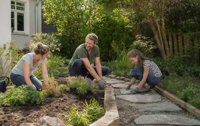 Familie geht auf einem Weg durch einen abwechslungsreich gestalteten Garten; Thema Mobiler Sichtschutz, Schwerpunkt DIY; Ergebnis.