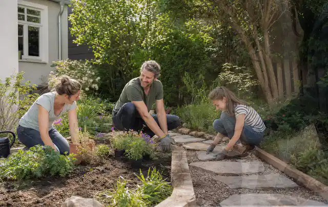 Familie geht auf einem Weg durch einen abwechslungsreich gestalteten Garten; Thema Moderner Garten, Schwerpunkt Fehlerhilfe; Umsetzung.