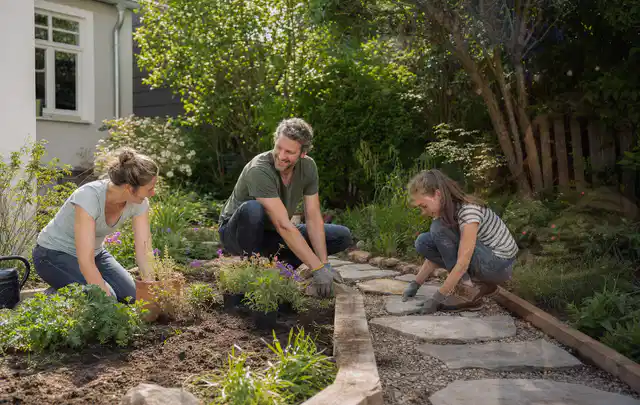 Familie geht auf einem Weg durch einen abwechslungsreich gestalteten Garten; Thema Moderner Garten, Schwerpunkt Privatsphäre; Umsetzung.