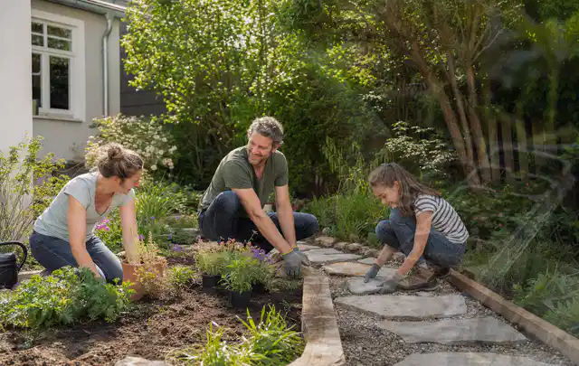 Familie geht auf einem Weg durch einen abwechslungsreich gestalteten Garten; Thema Naturgarten, Schwerpunkt Beleuchtung; Kontrolle.