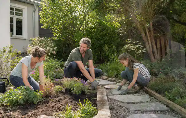 Familie geht auf einem Weg durch einen abwechslungsreich gestalteten Garten; Thema Naturgarten, Schwerpunkt Materialwahl; Umsetzung.
