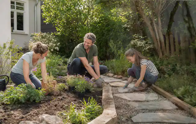 Familie geht auf einem Weg durch einen abwechslungsreich gestalteten Garten; Thema Naturgarten, Schwerpunkt Wegeführung; Praxisalltag.