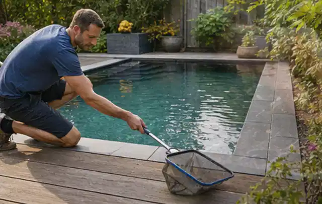 Person entfernt Blätter mit einem Kescher aus einem kleinen Gartenpool; Thema Outdoor Küchen, Schwerpunkt Checkliste; Ausgangslage.