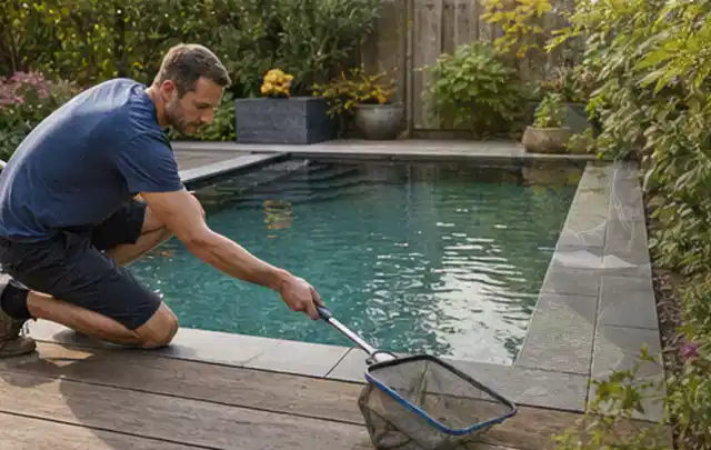 Person entfernt Blätter mit einem Kescher aus einem kleinen Gartenpool; Thema Outdoor Küchen, Schwerpunkt Kosten; Ausgangslage.
