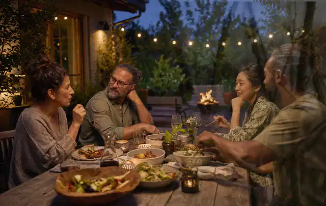 Menschen verbringen einen ruhigen Abend an einem Sitzplatz im Garten; Thema Outdoor Küchen, Schwerpunkt Reparatur; Ergebnis.