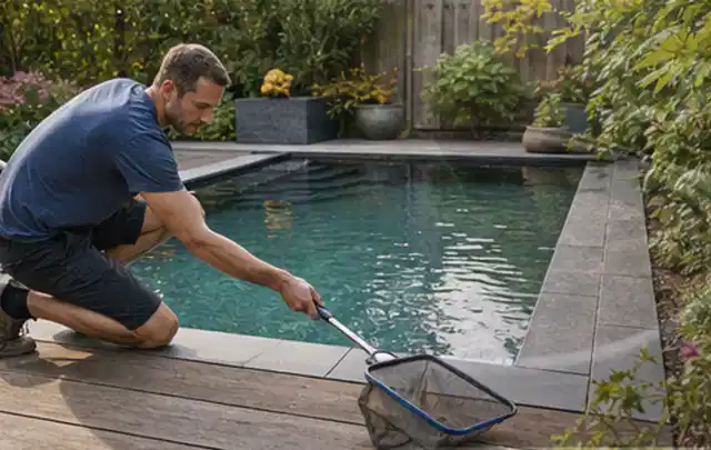 Person entfernt Blätter mit einem Kescher aus einem kleinen Gartenpool; Thema Outdoor Küchen, Schwerpunkt Systemvergleich; Ergebnis.