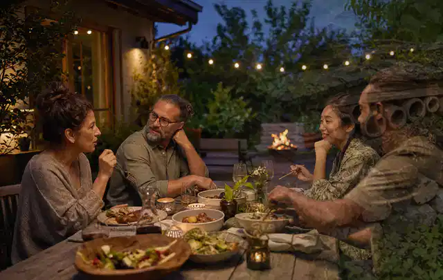 Menschen verbringen einen ruhigen Abend an einem Sitzplatz im Garten; Thema Outdoor Küchen, Schwerpunkt Testkriterien; Ausgangslage.