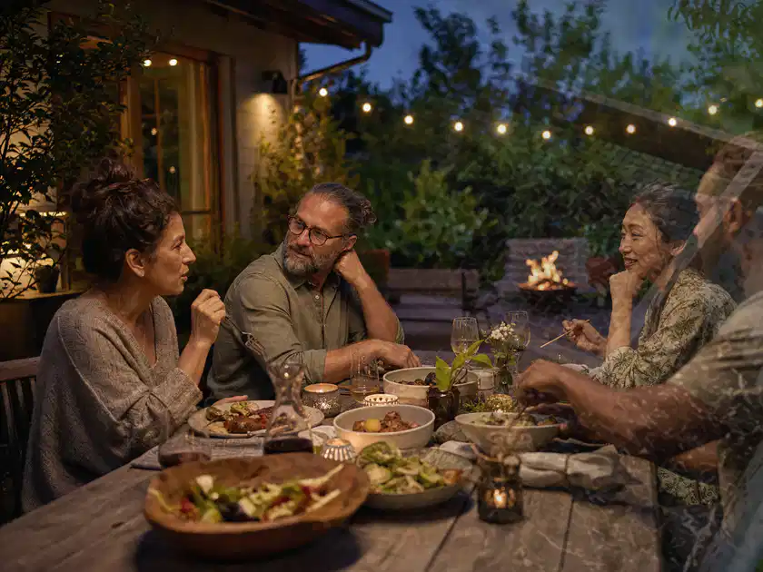 Menschen verbringen einen ruhigen Abend an einem Sitzplatz im Garten; Thema Outdoor Küchen, Schwerpunkt Vergleich; Titelbild.