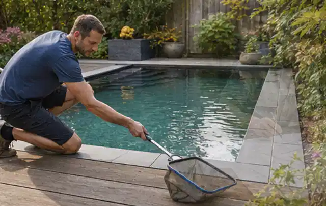 Person entfernt Blätter mit einem Kescher aus einem kleinen Gartenpool; Thema Outdoor Küchen, Schwerpunkt Winterlager; Ausgangslage.