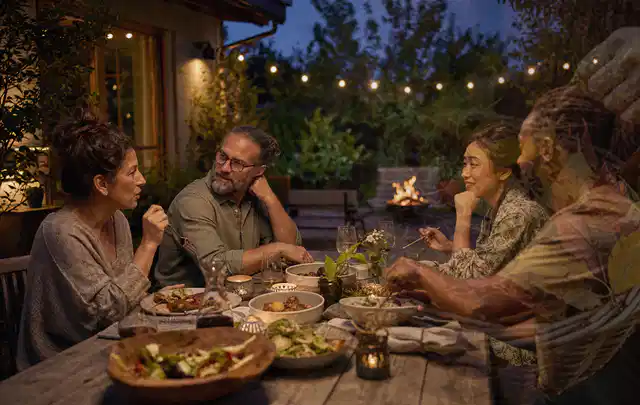 Menschen verbringen einen ruhigen Abend an einem Sitzplatz im Garten; Thema Pelletgrills, Schwerpunkt Bestenliste; Praxisalltag.