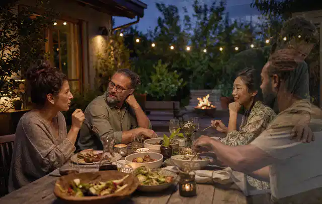 Menschen verbringen einen ruhigen Abend an einem Sitzplatz im Garten; Thema Pelletgrills, Schwerpunkt Dimensionierung; Umsetzung.