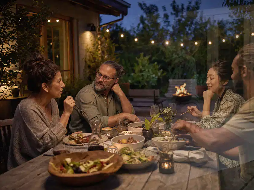 Menschen verbringen einen ruhigen Abend an einem Sitzplatz im Garten; Thema Pelletgrills, Schwerpunkt Systemvergleich; Titelbild.