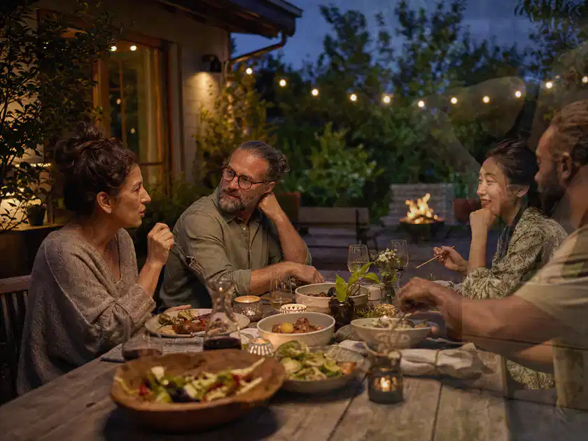Menschen verbringen einen ruhigen Abend an einem Sitzplatz im Garten; Thema Pergolen, Schwerpunkt Checkliste; Titelbild.
