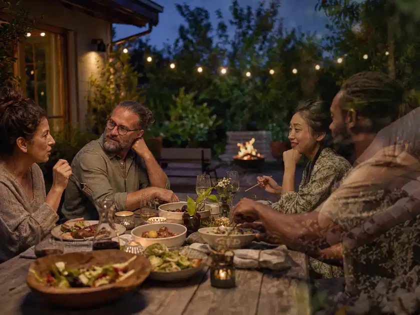 Menschen verbringen einen ruhigen Abend an einem Sitzplatz im Garten; Thema Pergolen, Schwerpunkt Fehlerhilfe; Titelbild.