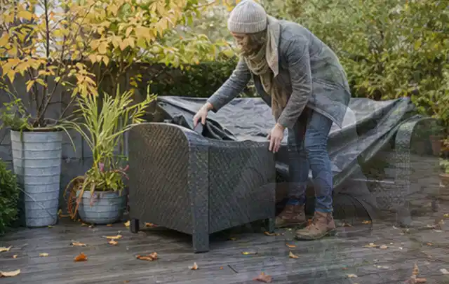 Person deckt Gartenmöbel vor der kalten Jahreszeit sorgfältig ab; Thema Pergolen, Schwerpunkt Reparatur; Ausgangslage.