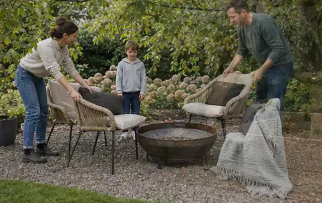 Familie stellt wetterfeste Sessel an einem geschützten Sitzplatz im Garten auf; Thema Pergolen, Schwerpunkt Winterlager; Kontrolle.