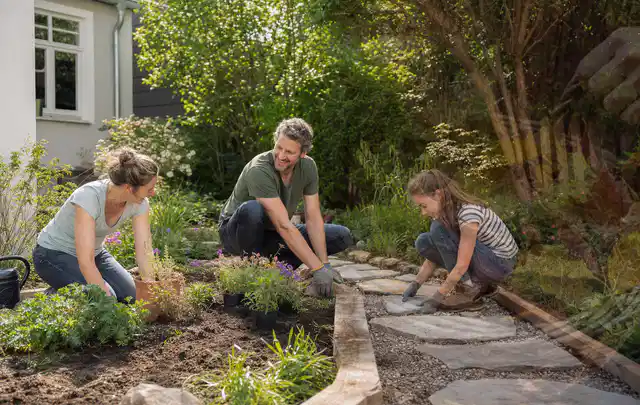 Familie geht auf einem Weg durch einen abwechslungsreich gestalteten Garten; Thema Pflegeleichter Garten, Schwerpunkt Checkliste; Kontrolle.
