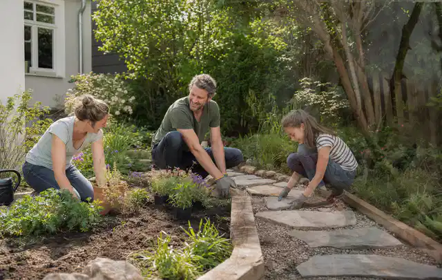 Familie geht auf einem Weg durch einen abwechslungsreich gestalteten Garten; Thema Pflegeleichter Garten, Schwerpunkt Fehlerhilfe; Ausgangslage.
