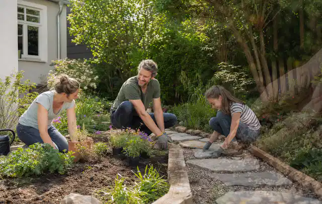 Familie geht auf einem Weg durch einen abwechslungsreich gestalteten Garten; Thema Pflegeleichter Garten, Schwerpunkt Materialwahl; Umsetzung.