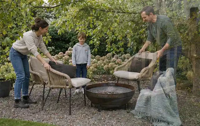 Familie stellt wetterfeste Sessel an einem geschützten Sitzplatz im Garten auf; Thema Pizzaöfen, Schwerpunkt Kaufberatung; Kontrolle.