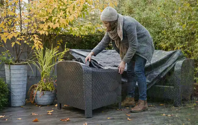 Person deckt Gartenmöbel vor der kalten Jahreszeit sorgfältig ab; Thema Poolchemie, Schwerpunkt Systemvergleich; Umsetzung.